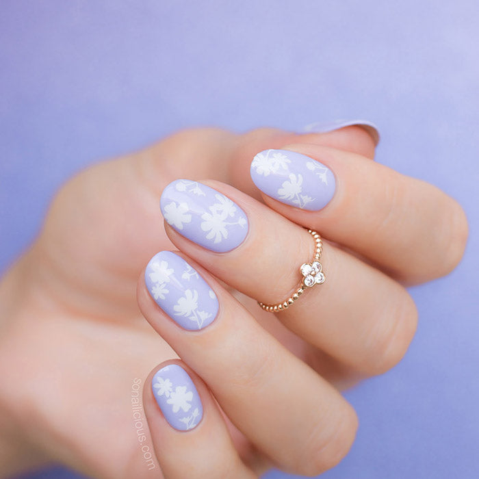 Purple nails with white floral nail stickers